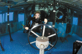 潜水人员抓住“基帝维克”号的方向盘，它很快就会成为海洋生物的聚居地。