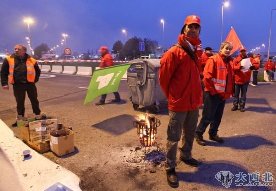 2012年1月30日，比利时布鲁塞尔，货运工业季度，罢工者站在马路对面。