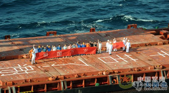 图为2011年12月中国商船“祥华门”号在甲板上打出“祖国万岁”横幅和五星红旗。 记者 高飞摄（资料图片）