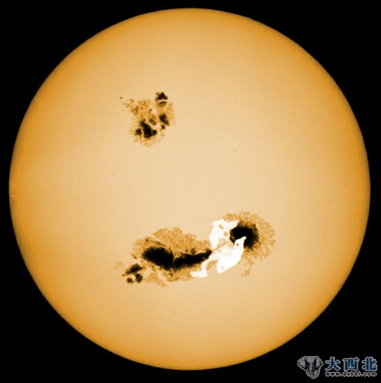 示意图：一颗发生超级耀斑爆发事件的恒星。这样的恒星表面会存在大型的黑子结构，其规模远远超过太阳上黑子的规模。图上可见，在靠近一处黑子结构附近发生了一次超级耀斑爆发事件(白色区域)