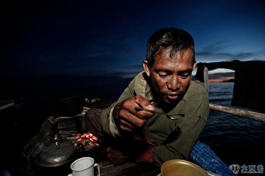 印尼苏拉威西岛海域，巴瑶族男子阿姆加·卡西姆·德莱塞正在船上吃晚饭。