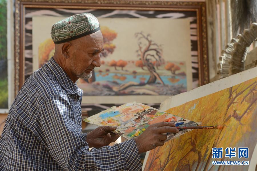 来自新疆和田地区墨玉县扎瓦镇库木艾日克村的“农民画家”阿卜力克木·麦麦提敏在家中进行油画创作（2019年3月5日摄）。