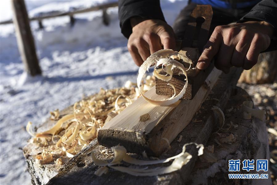 新疆阿勒泰地区布尔津县禾木村的牧民森格尔在制作毛皮滑雪板（2019年1月3日摄）。