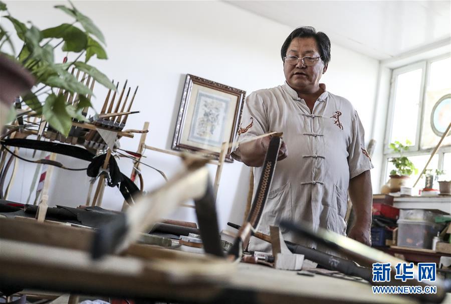 来自新疆伊犁哈萨克自治州察布查尔锡伯自治县的弓箭艺人赵玉书在工作室内制作传统弓箭（2018年9月14日摄）。